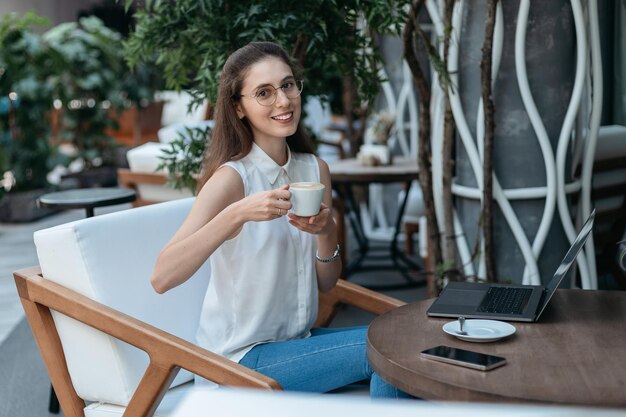 Mujer joven con una taza de café sentada en un acogedor café