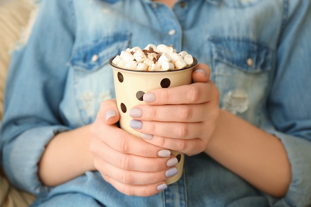 Mujer joven, con, taza, de, sabroso, cacao, bebida, en casa, primer plano