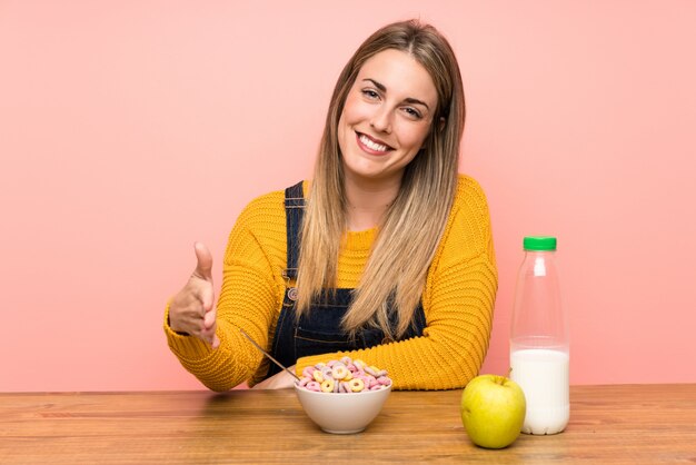 Mujer joven con tazón de cereales apretón de manos después de mucho