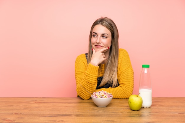 Mujer joven con tazón de cereales pensando una idea