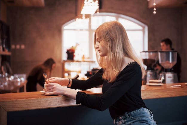 Mujer joven con teléfono en un café.