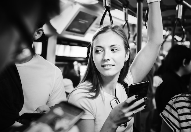 Mujer joven con un teléfono inteligente en el metro