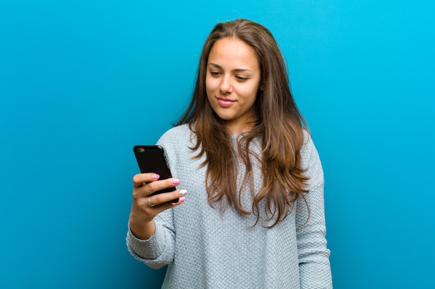 Mujer joven con un teléfono móvil en azul