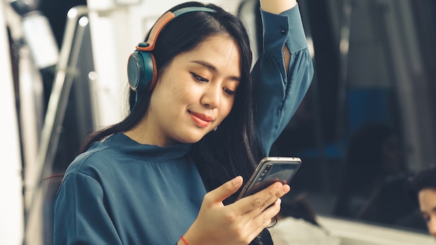 Mujer joven con teléfono móvil en tren público