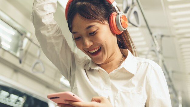 Mujer joven con teléfono móvil en tren público