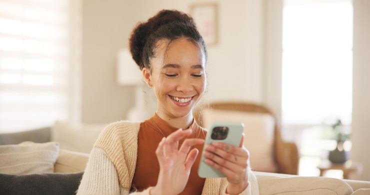 Foto mujer joven teléfono y reír en el sofá pensando y relajarse en la sala de estar de la casa para enviar mensajes de texto chat web o blog niña emocionada sonrisa y teléfono inteligente con clic meme o aplicación de red social en el sillón sofá