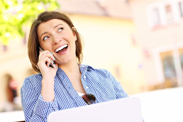 Mujer joven con teléfono sentado en un banco