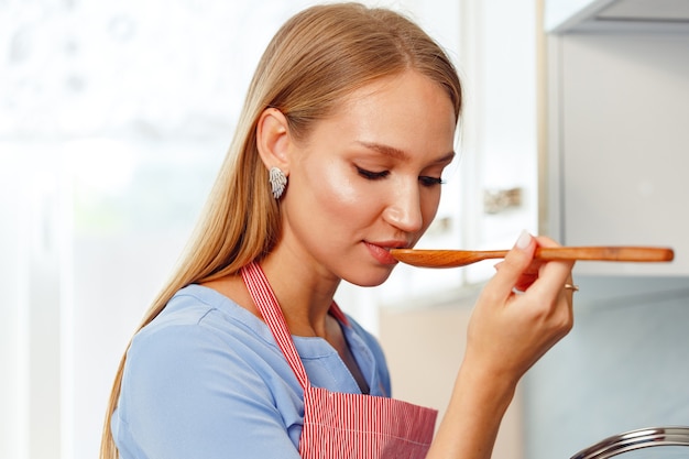 Mujer joven, tenencia, cuchara de madera, en, cocina