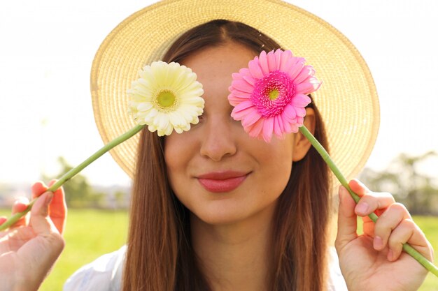 Mujer joven, tenencia, flores, en, ella, ojos