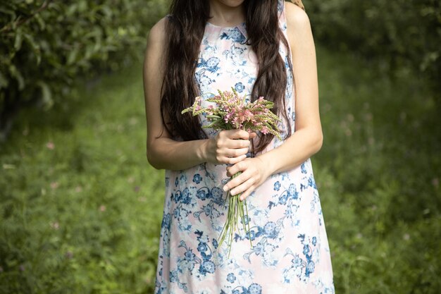 Mujer joven, tenencia, flores, en el jardín