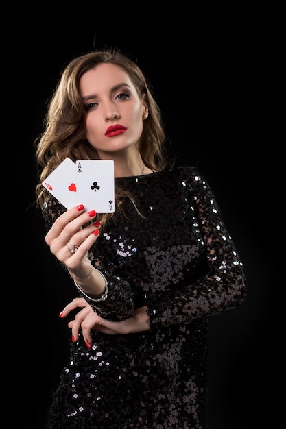 Mujer joven, tenencia, juego de cartas, contra, un, fondo negro