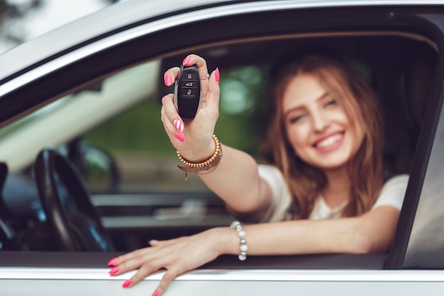 Foto mujer joven, tenencia, llaves, a, coche nuevo