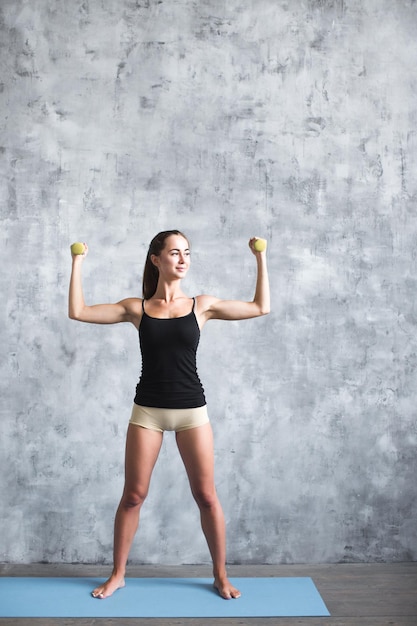 mujer joven, tenencia, pesas, bienestar, concepto