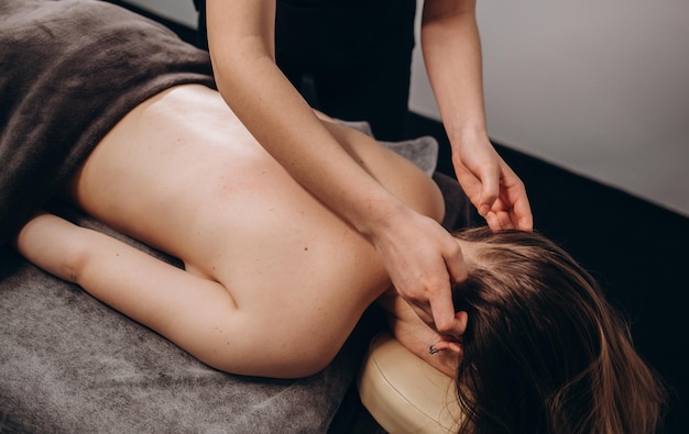 Mujer joven, teniendo, masaje facial, en, salón de belleza