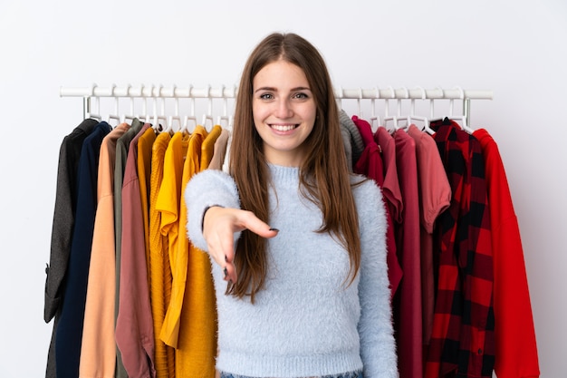 Mujer joven en una tienda de ropa apretón de manos después de un buen trato