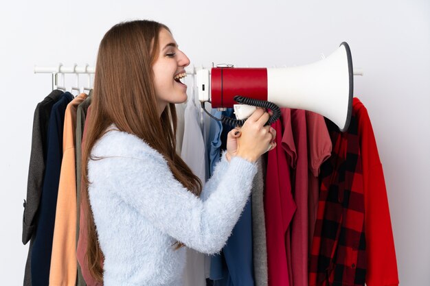 Mujer joven en una tienda de ropa con un megáfono