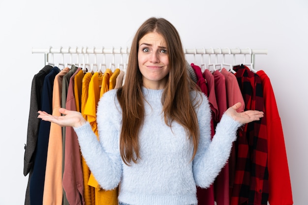 Mujer joven en una tienda de ropa que tiene dudas con confundir la expresión de la cara