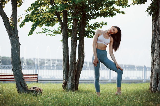 Mujer joven con tipo de cuerpo delgado posando en el parque