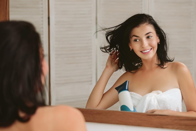 Foto mujer joven, en, toalla de baño, secado, pelo
