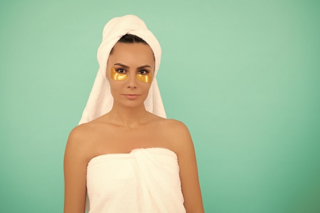 Mujer joven en toalla de ducha con parche dorado