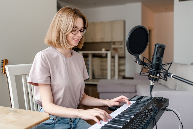 Mujer joven, tocar el piano, en casa