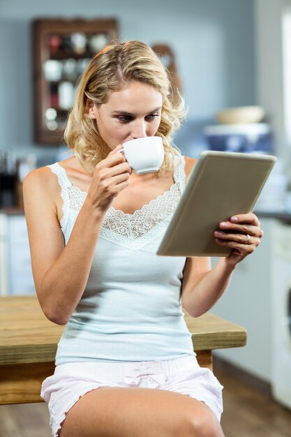 Mujer joven tomando café en casa