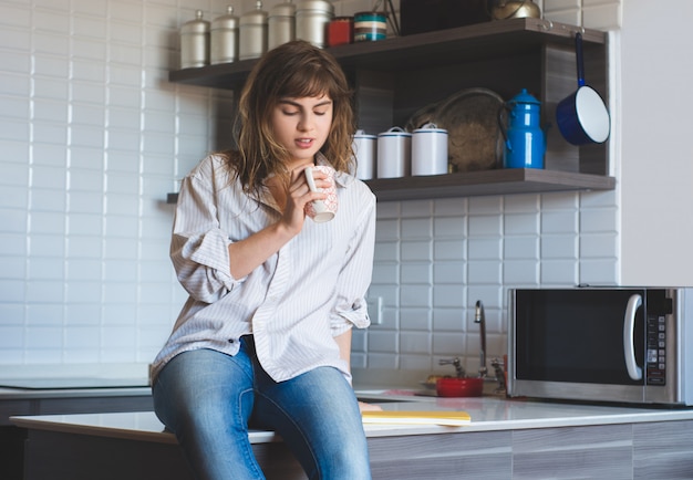 Mujer joven tomando café en casa