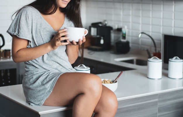 Mujer joven tomando café en casa
