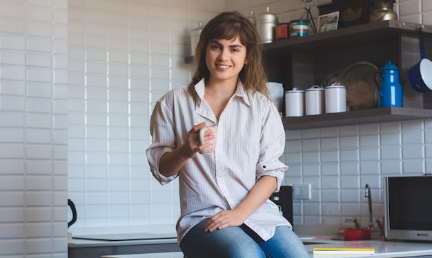 Mujer joven tomando café en casa