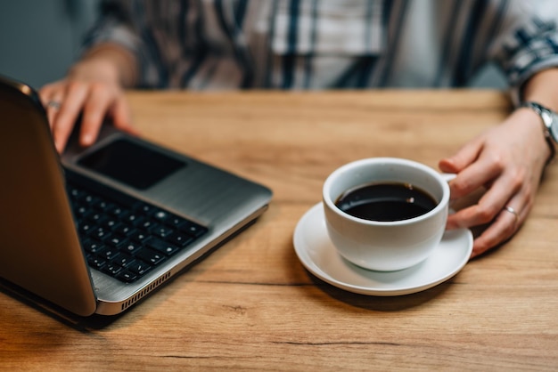 Mujer joven tomando café y trabajando en casa