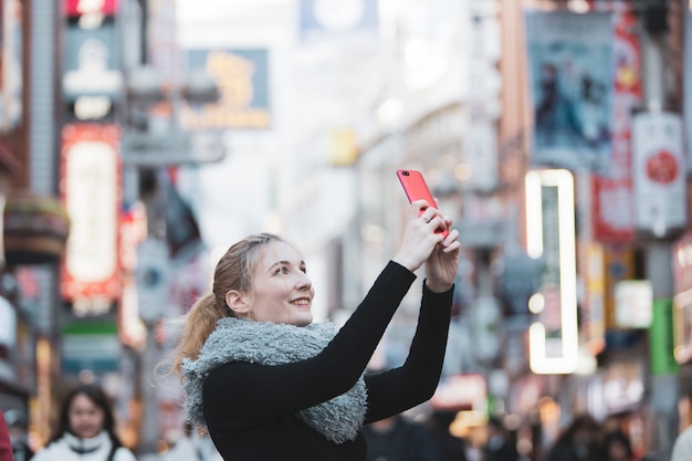 Mujer joven tomando fotos de la ciudad de Tokio