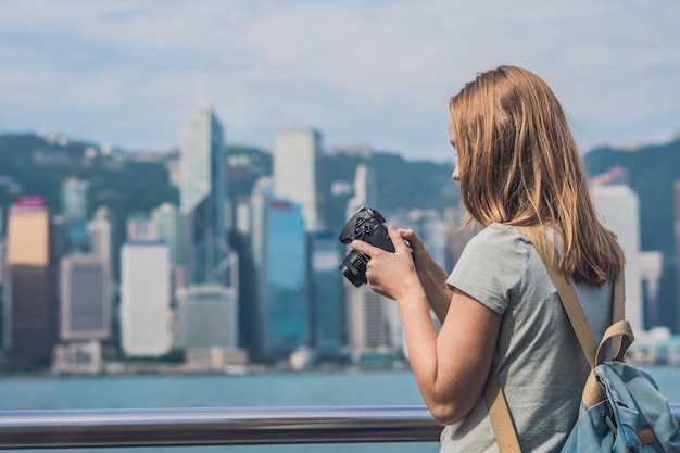 Mujer joven tomando fotos del puerto de victoria en Hong Kong, China