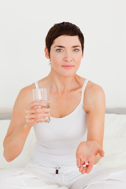 Mujer joven tomando pastillas