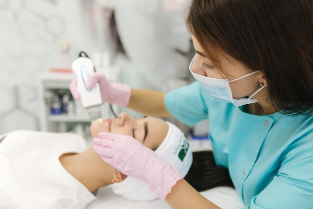 Mujer joven tomando procedimiento de belleza en el salón de spa