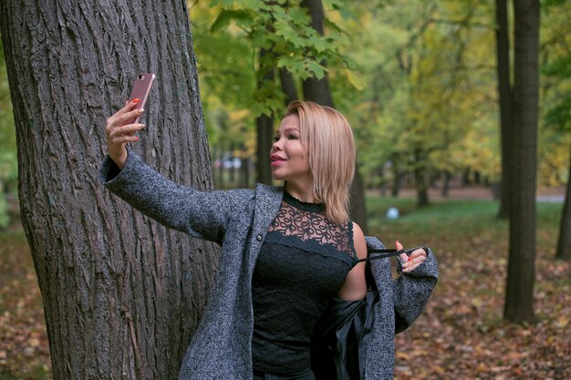 Mujer joven tomando una selfie en el parque