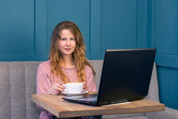 Mujer joven trabaja para una computadora portátil