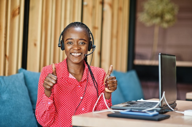 Mujer joven trabaja en un operador de centro de llamadas y agente de servicio al cliente con auriculares con micrófono trabajando en una computadora portátil