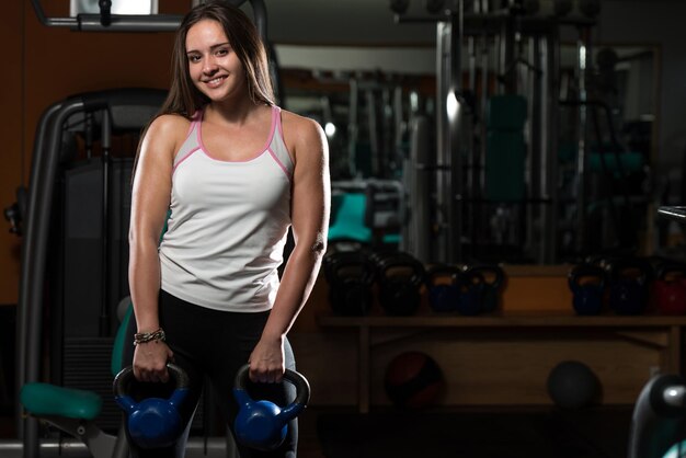 Mujer joven trabajando con Kettle Bell