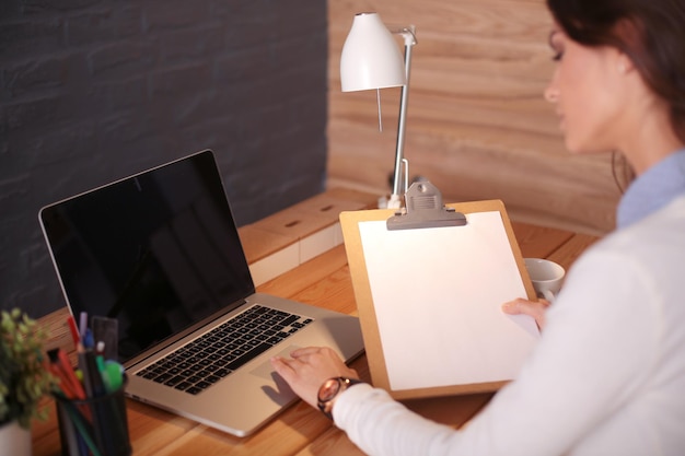 Mujer joven trabajando sentada en un escritorio