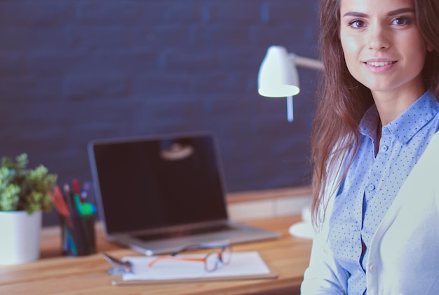 Mujer joven trabajando sentada en un escritorio