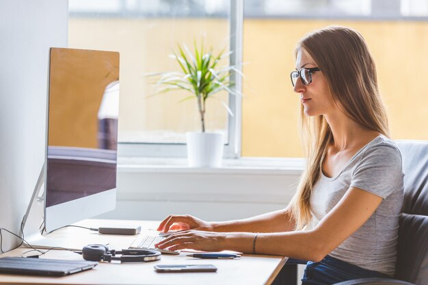 Foto mujer joven en el trabajo, situación de la oficina en casa