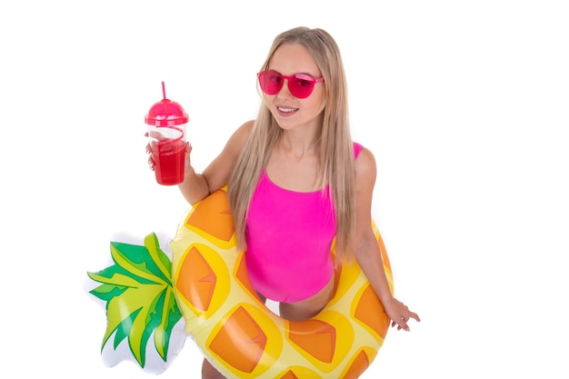 Foto una mujer joven en un traje de baño brillante sostiene un vaso de limonada fondo blanco ilustraciones para las vacaciones de verano