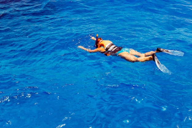 Mujer joven en traje de baño snorkeling