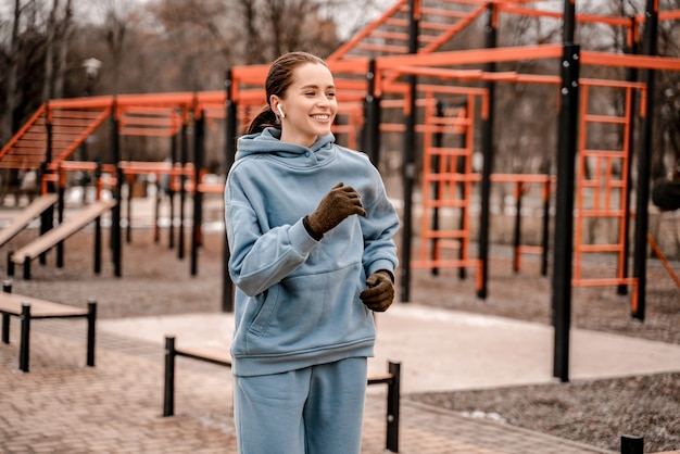 Mujer joven en traje deportivo haciendo ejercicio matutino al aire libre