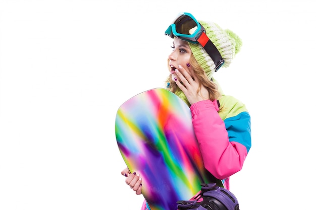 Mujer joven en traje de esquí con tabla de snowboard