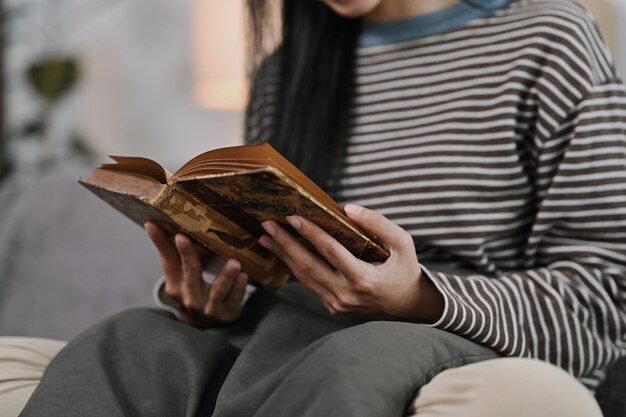 Foto mujer joven tranquila leyendo un libro en el sofá en casa conceptos de ocio y estilo de vida de la gente