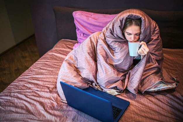 Mujer joven tranquila y pacífica se sienta en la cama