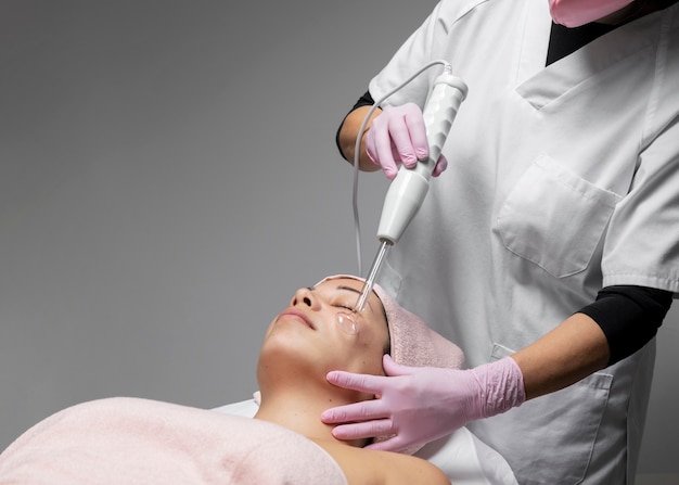 Mujer joven con un tratamiento facial en el salón de belleza