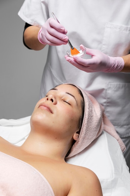 Foto mujer joven con un tratamiento facial en el salón de belleza