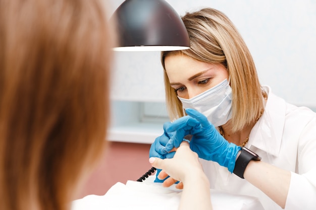 Mujer joven en tratamiento de manicura en salón de belleza